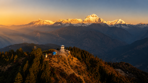 Poon Hill sunrise over the Annapurna mountain range, with golden morning rays illuminating the Himalayan peaks.