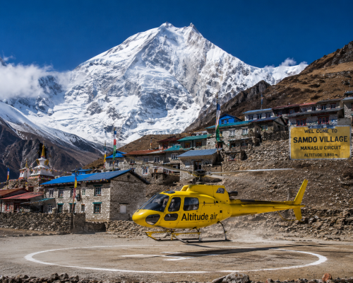 Manaslu Circuit Helicopter Return Trek with yellow Altitude Air helicopter landing at Samdo Village below Mount Manaslu