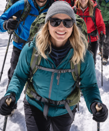German trekkers crossing snowy Cho La Pass with Himalayan peaks behind.